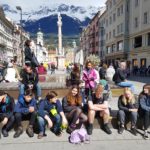 Group of teenagers sitting in Innsbruck town centre
