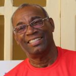 Caribbean man with glasses and smiling